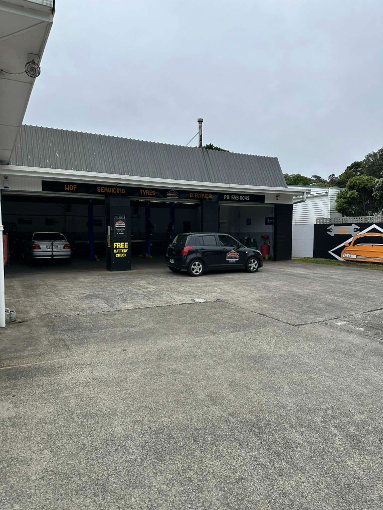Auto Centre Johnsonville workshop exterior with open bays and the branded courtesy car